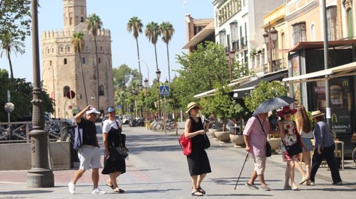 Turistas se protegen del sol durante su paseo