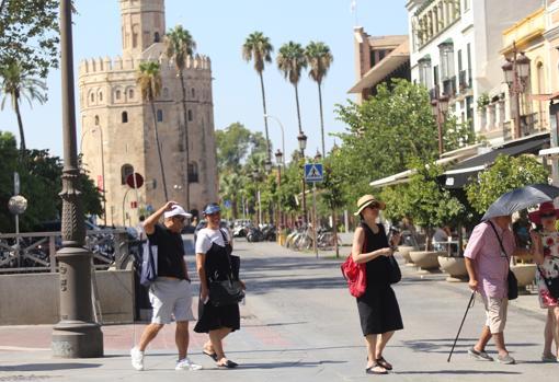 Grupo de turistas paseando por el entorno de la Torre del Oro