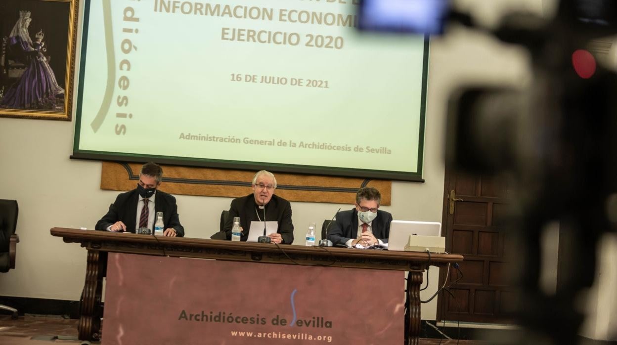 El arzobispo de Sevilla, junto al ecónomo y al jefe de prensa, durante la presentación de las cuentas