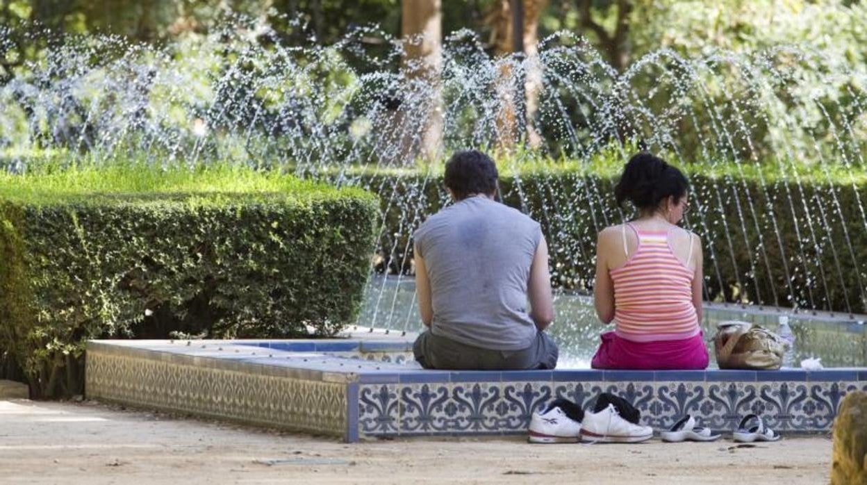 Dos personas se refrescan en una fuente