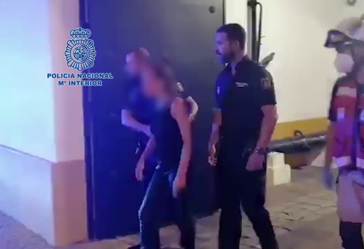 Los agentes acompañan a la mujer rescatada a la ambulancia