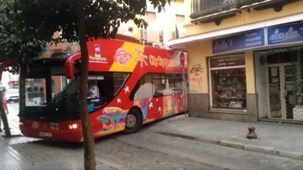 Un autobús atrapado en la calle Conde de Torrejón esquina con Feria sale con la ayuda de la Policía y de los bomberos