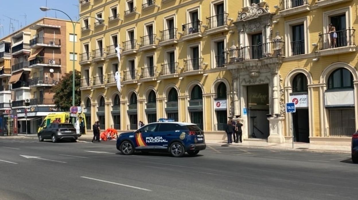 Los sanitarios y los agentes atienden al hombre en el suelo tras caer por la fachada del hotel