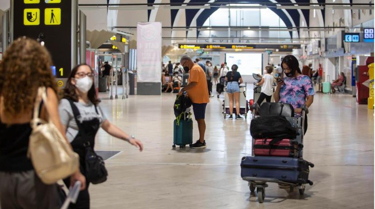 Varios pasajeros en el vestíbulo del aeropuerto de Sevilla