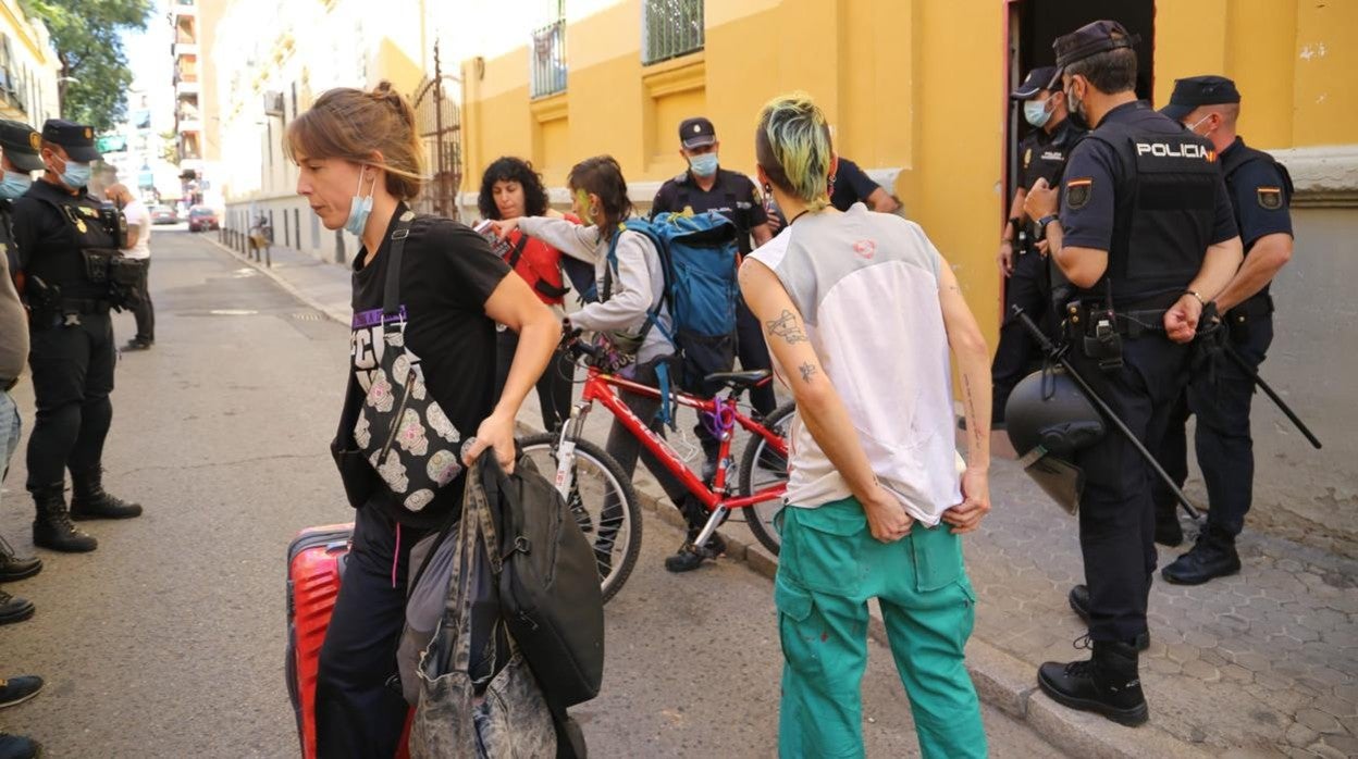 Jóvenes okupas saliendo de las viviendas con sus pertenencias