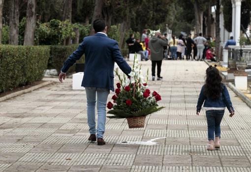 Mayores y pequeños cumplen con el rito en el camposanto sevillano