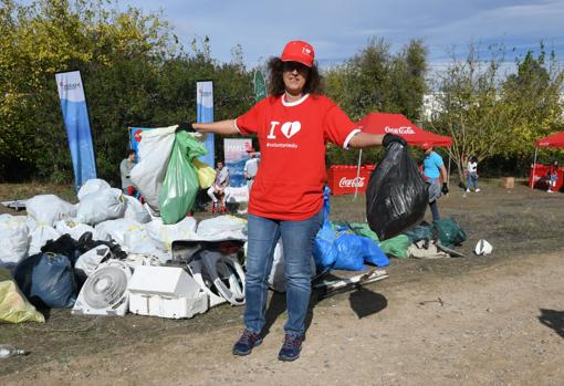 Una voluntaria recogiendo residuos en la ribera del río