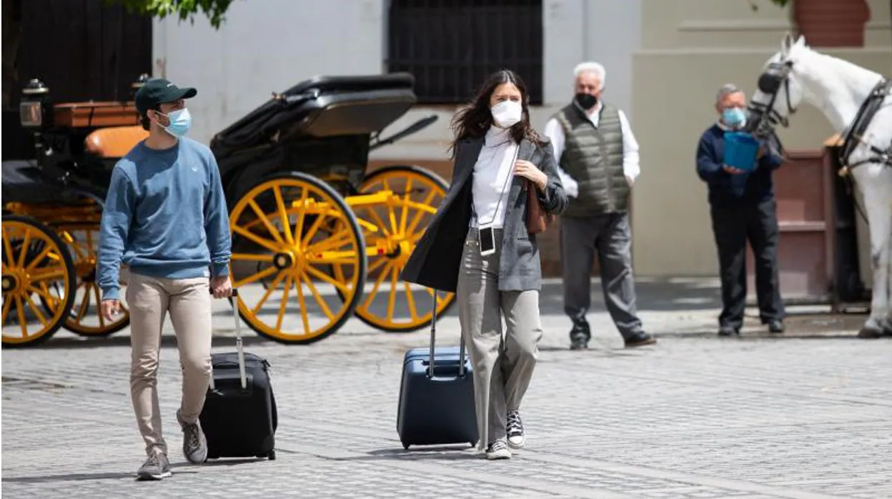 Dos viajeros con sus maletas en el Centro de Sevilla