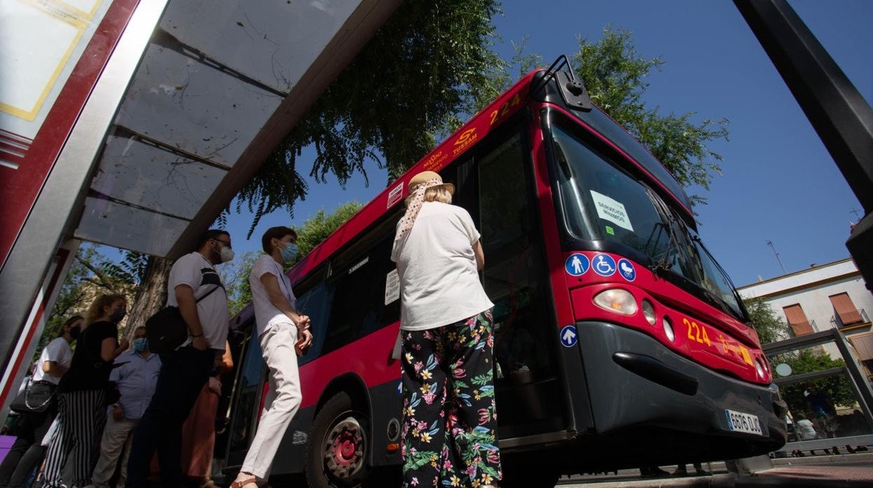 Cola de personas para subir a un autobús de Tussam en la plaza Ponce de León