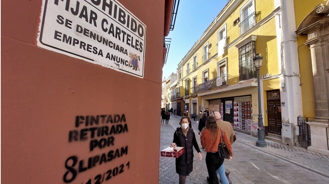 Otra pintada de Lipasam en la calle Feria, justo debajo de un cartel de 'Prohibido fijar carteles