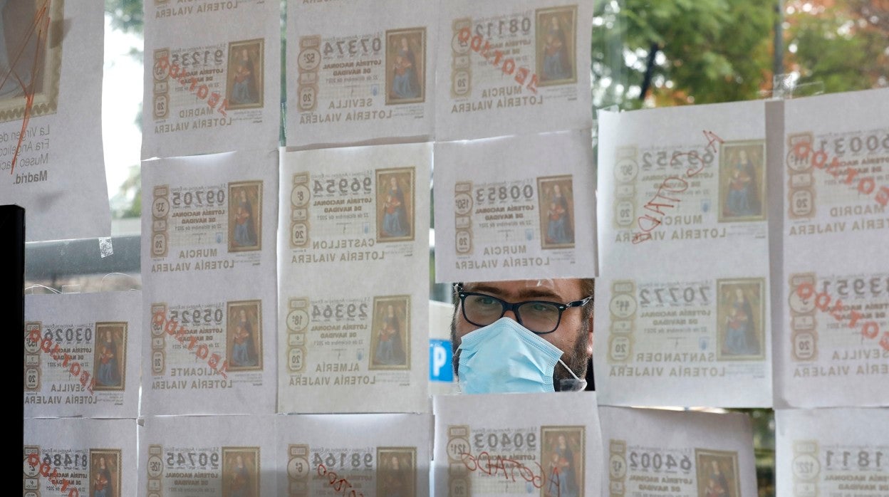 Un hombre mira los décimos de lotería