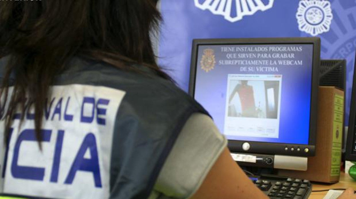 Una agente de la Policía Nacional inspecciona la documentación relativa a una investigación anterior de acoso por Internet