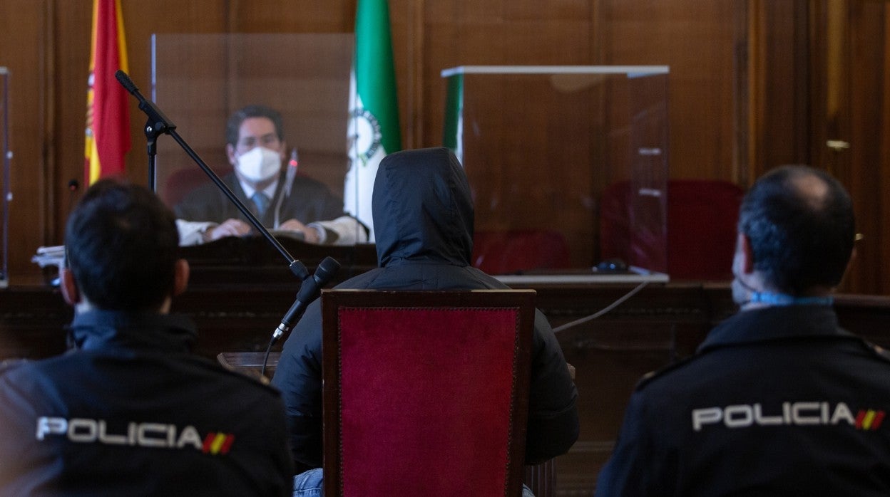 La Policía escolta al acusado, sentado frente al presidente del tribunal, durante el primer día del juicio con jurado