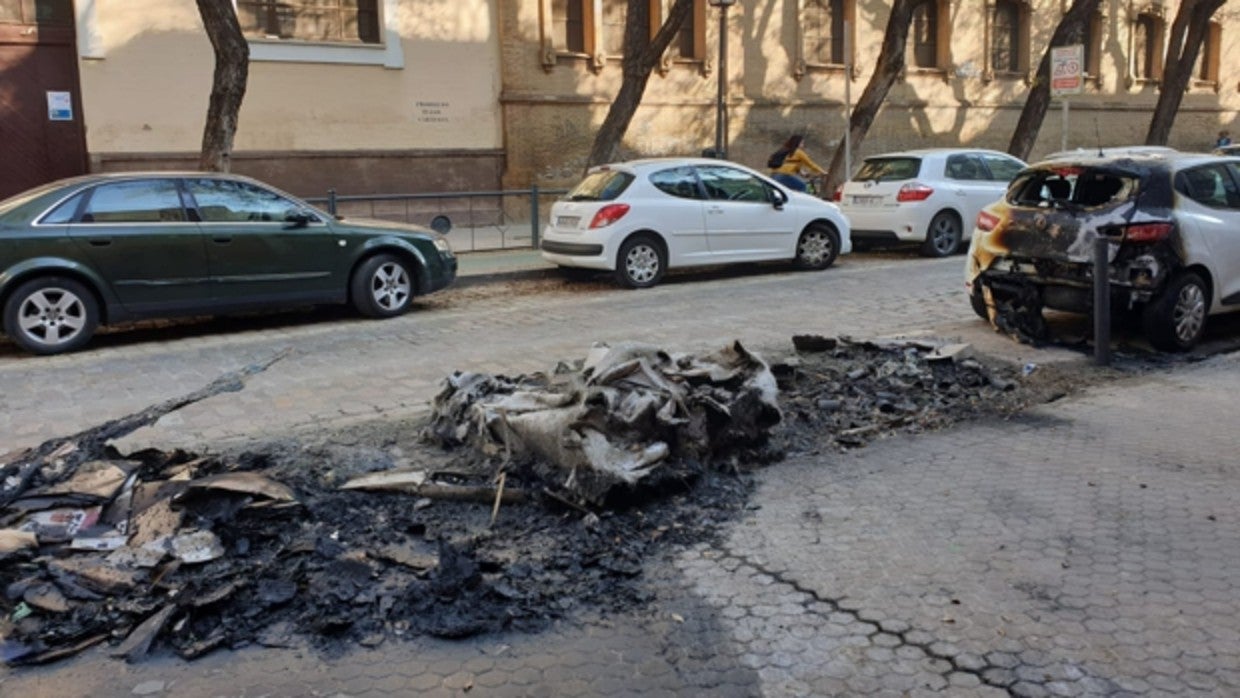 Contenedor quemado en la calle San Jacinto, que afectó a un vehículo estacionado