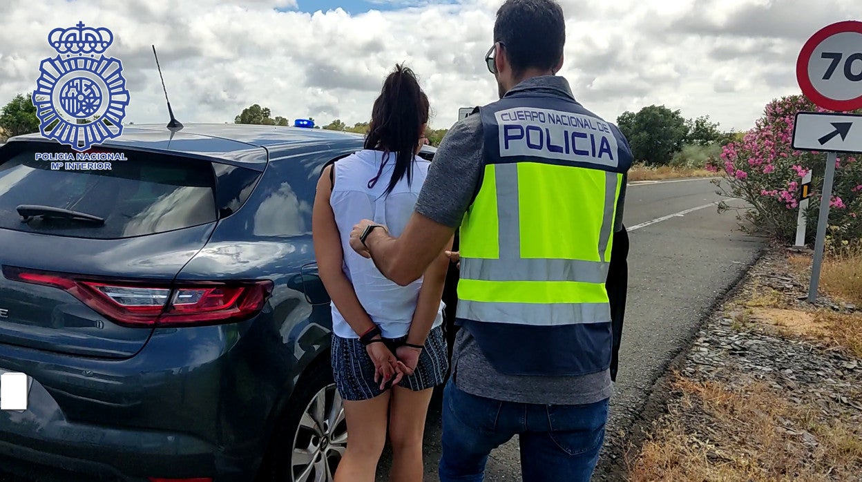 Un agente conduce a una de las detenidas al vehículo policial tras ser interceptadas en la autovía