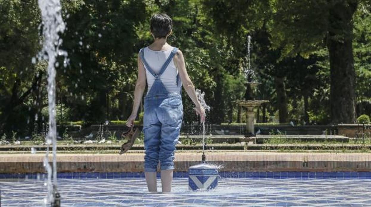 Una mujer se refresca en una fuente del parque de María Luisa de Sevilla