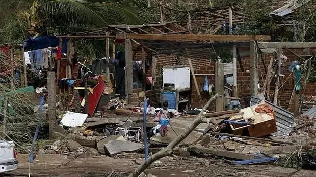 Una niña contempla su casa, destrozada por el huracán Patricia