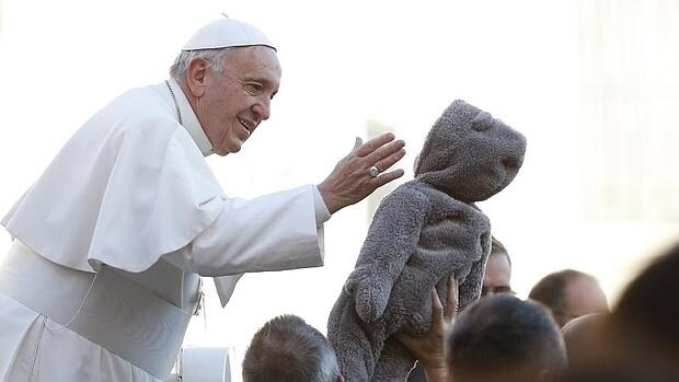 El Papa bendice a un niño a su llegada a la plaza de San Pedro para participar en la audiencia general