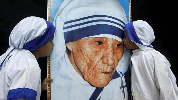 Dos niñas besan un retrato de la madre Teresa de Calcuta en la India
