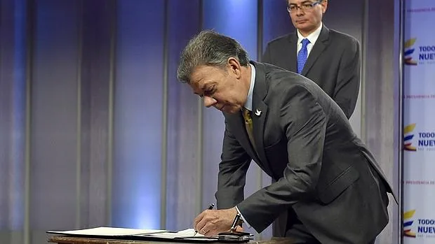 Juan Manuel Santos (i) y el ministro de salud, Alejandro Gaviria, durante la firma del decreto en la Casa de Nariño, Bogotá (Colombia)