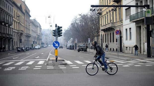 Un ciclista circula por las calles de Milán (Italia)