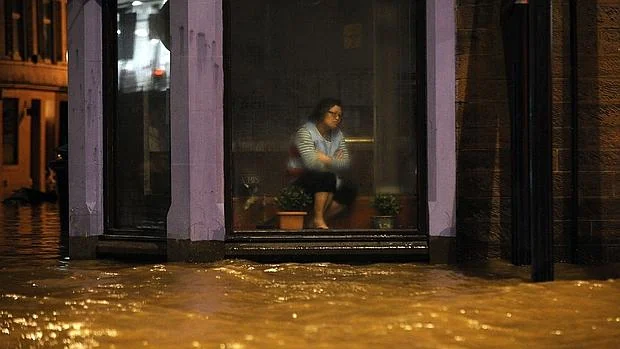 Una mujer espera dentro de un restaurante a que amaine la tormenta Frank, en Dumfries, al sur de Escocia