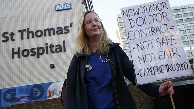 Una doctora sostiene una pancarta contra el nuevo contrato de médico junior en Inglaterra