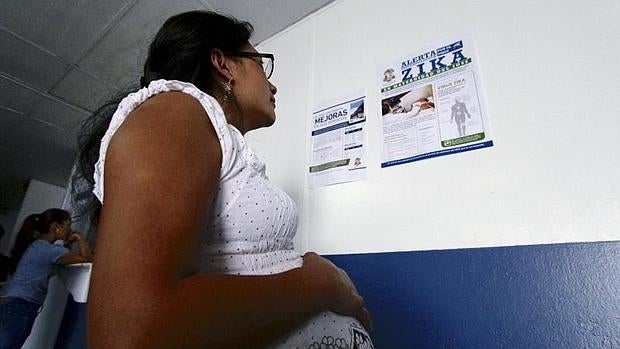 Una mujer embarazada lee un comunciado sobre el virus Zika en un hospital de Guatemala