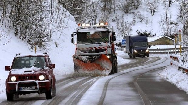 Una máquina quitanieves limpia la carretera de Pajares que se encuentra cubierta de nieve en la tarde de ayer lunes