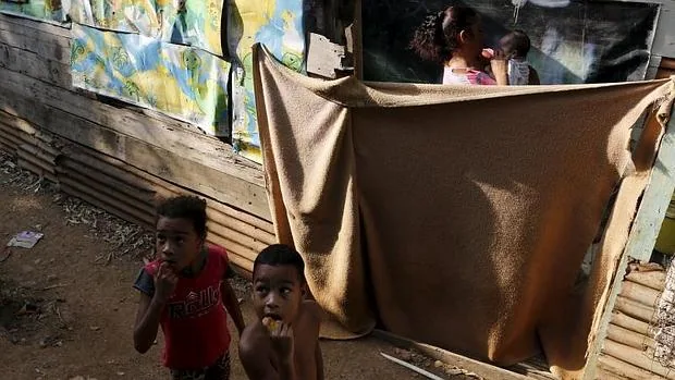Unos niños fuera de su chabola mientras fumigan el poblado ubicado en Veracuz, a las afueras de la ciudad de Panamá