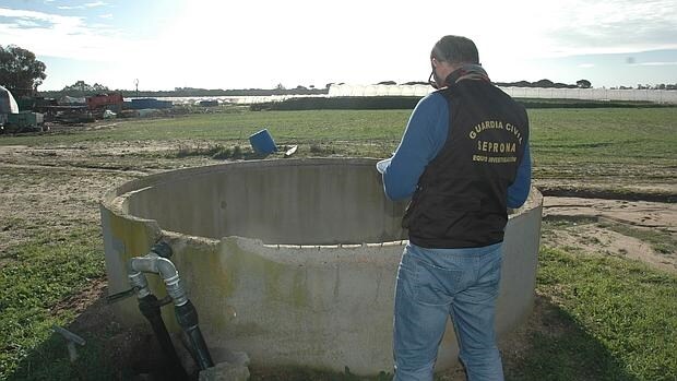Un agente del Seprona revisa un pozo en una finca del entorno de Doñana