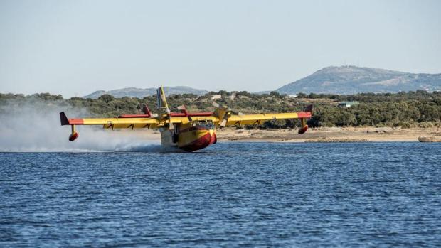 Un hidroavión reposta agua en el Pantano de Valdesalor como parte de las labores de extinción