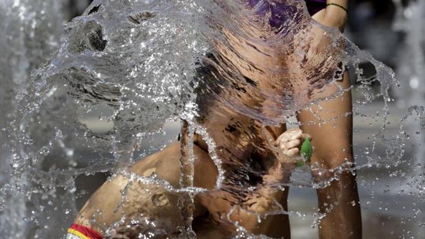 Un niño se divierte con el agua de una fuente