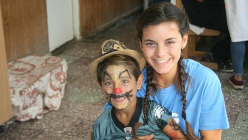 Almudena Salort, junto a un niño de las casas de acogida que pintaron en Rumarnía