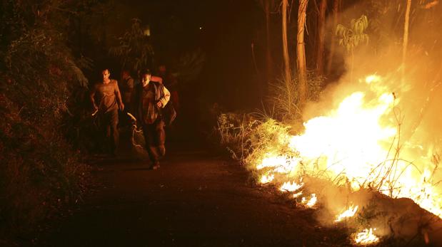 Varios vecinos intentan sofocar las llamas del incendio forestal de Arbo (Pontevedra)