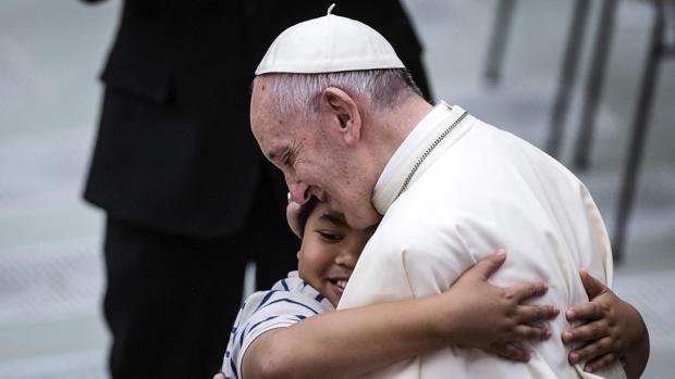 El papa Francisco abraza a un joven