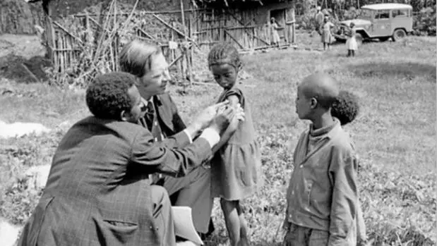 Donald A. Henderson y un ayudante vacunan a niños en una aldea etíope