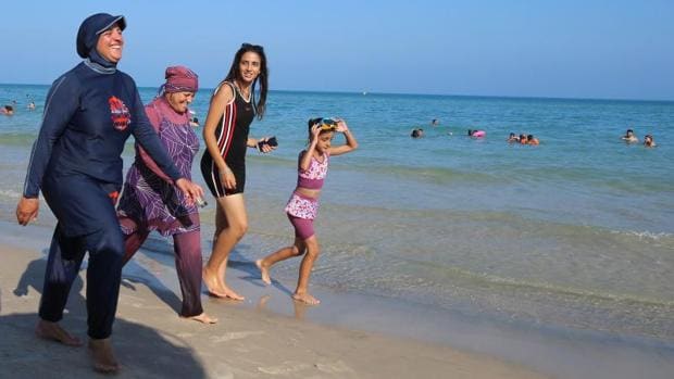 Dos mujeres con burkini pasean por la playa