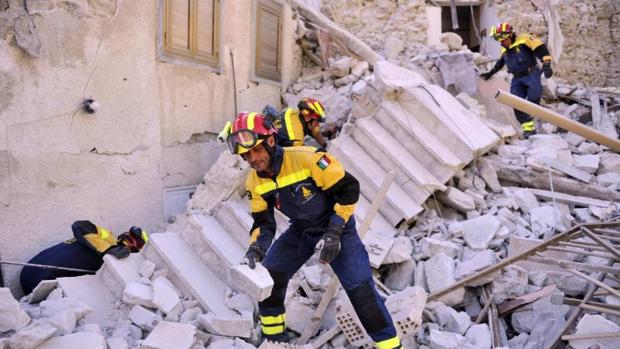 Varios bomberos trabajan entre los escombros producidos por el terremoto en Pescara del Tronto