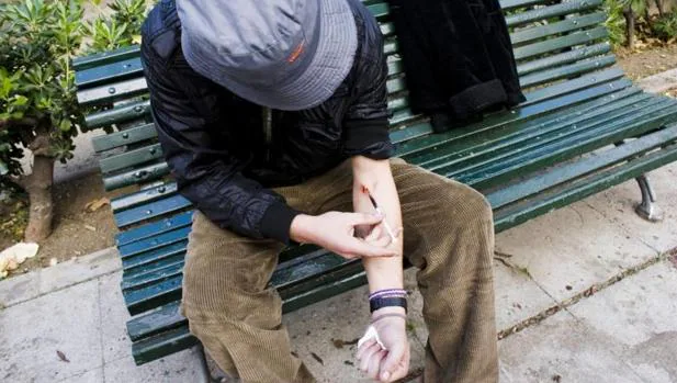 Un adicto se inyecta heroína en un parque