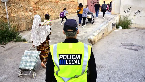 Un policía local observa la entrada de los niños al colegio público del barrio obrero de Son Roca de la capital balear