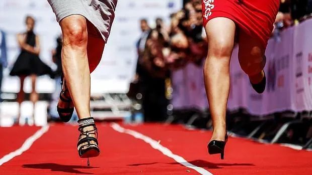 Fotografía de archivo de dos mujeres corriendo con tacones