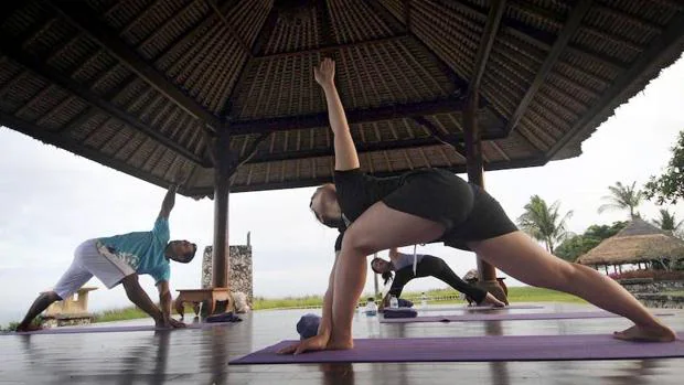 Un grupo de personas practica yoga