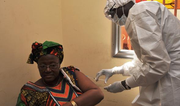 Foto de 2015 que muestra a personal sanitario poniéndole una vacuna a una mujer en Guinea Conakry