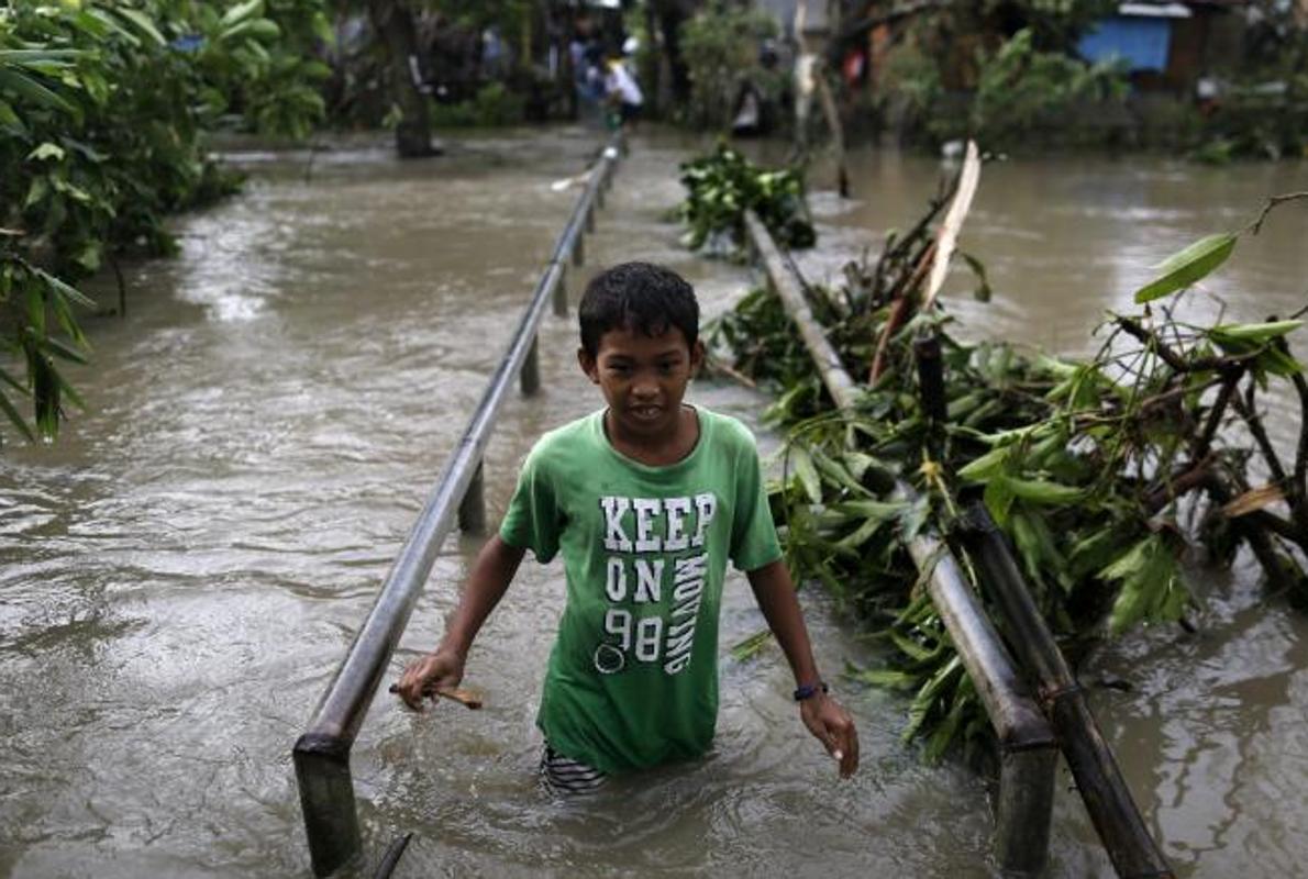 Un adolescente en una zona inundada por el paso del tifón Nock-Ten por la localidad de Pamplona, Camarines Sur