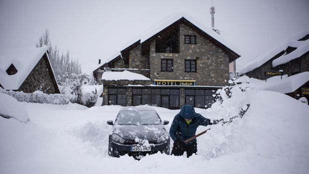 Un hombre intenta desenterrar su coche en Benasque, tras la gran nevada caída en el Pirineo