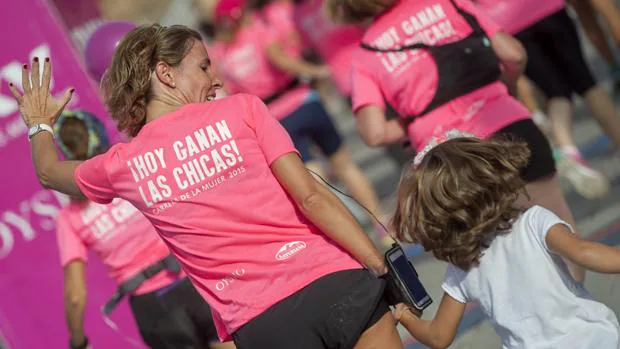 Una madre corre con su hija en la carrera de la mujer en Sevilla