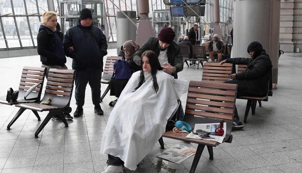 El peluquero atiende a una mujer en una zona pública de la ciudad francesa