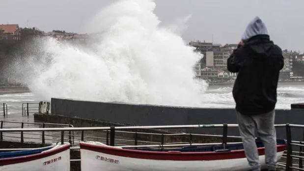 Un hombre fotografía las olas que rompían ayer martes en el Puerto Viejo de Algorta (Vizcaya)