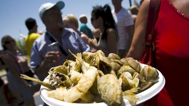 Una mujer muestra un plato de pescado frito